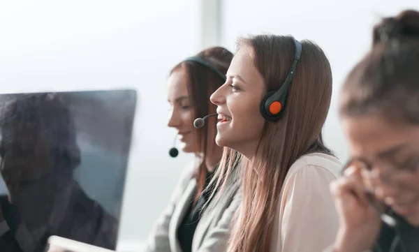 Sorrindo operador de call center sentado em sua mesa — Fotografia de Stock