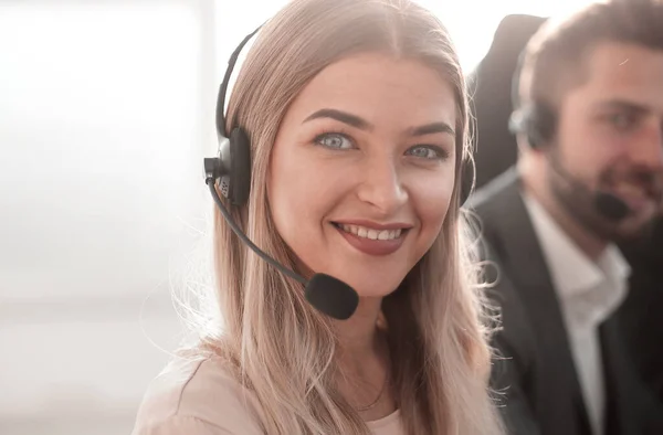 Young call center operators on the background of her colleagues — Stock Photo, Image