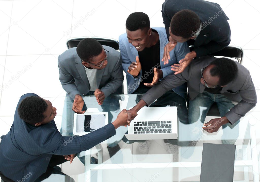 top view. business colleagues shaking hands during office meeting.