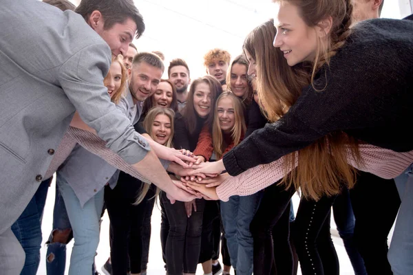 Большая группа молодых единомышленников, объединяющих свои ладони — стоковое фото