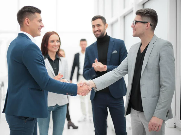 Бізнес-партнери тремтять руками, стоячи в офісі — стокове фото