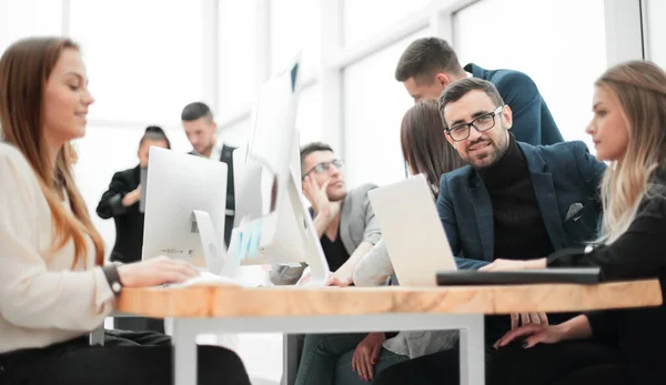 Joven empresario y grupo de trabajo sentado en la oficina Escritorio — Foto de Stock