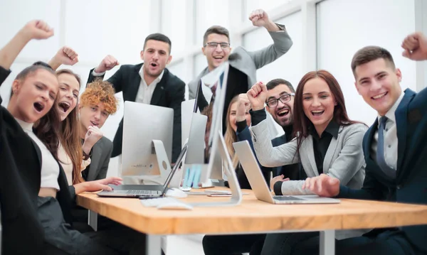 Grupp glada kontorsanställda sitter vid ett bord. — Stockfoto