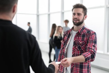 Genç tasarımcı kartvizitini yeni bir müşteriye veriyor.