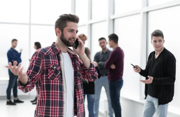 Leende ung designer läser ett meddelande på sin smartphone — Stockfoto