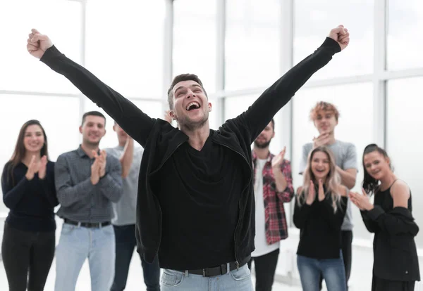 Giovane imprenditore in piedi di fronte al team di lavoro applaudente — Foto Stock