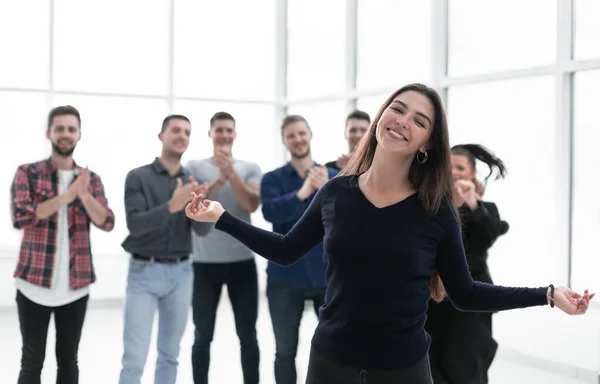 Счастливая деловая женщина, стоящая перед аплодирующими коллегами — стоковое фото