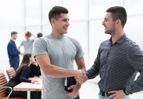 Due giovani dipendenti che discutono un documento aziendale — Foto Stock
