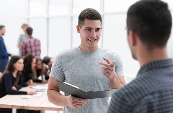 Dos jóvenes empleados discutiendo un documento de negocios — Foto de Stock