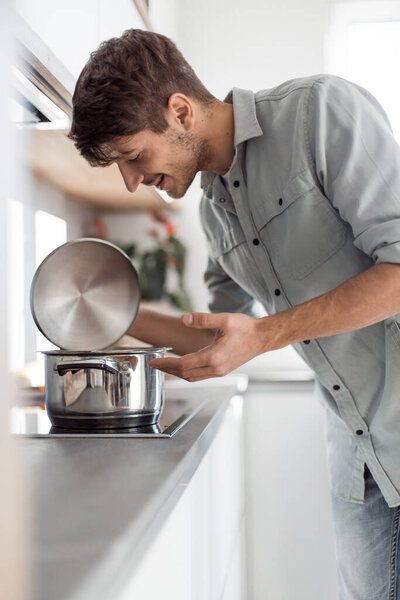 улыбающийся молодой работник сидит за своим столом и указывает на тебя
