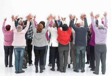 Bir grup yetişkin insan ellerini kaldırıyor.