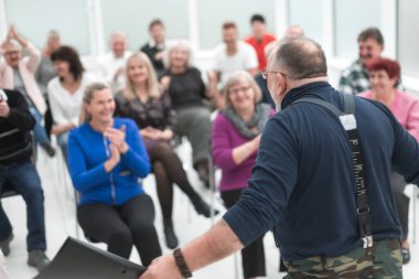 Olgun beyaz adam modern açık ofiste bir konuşma yapıyor.