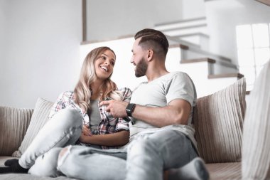 Sıcak oturma odasındaki kanepede oturan sevgili çift.