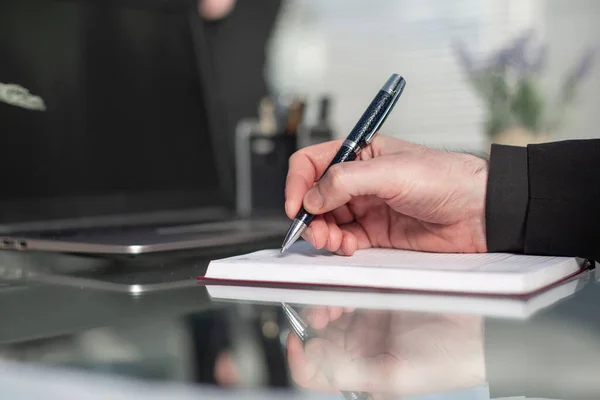 Empresário escreve com uma caneta no diário em um escritório ensolarado, busine — Fotografia de Stock