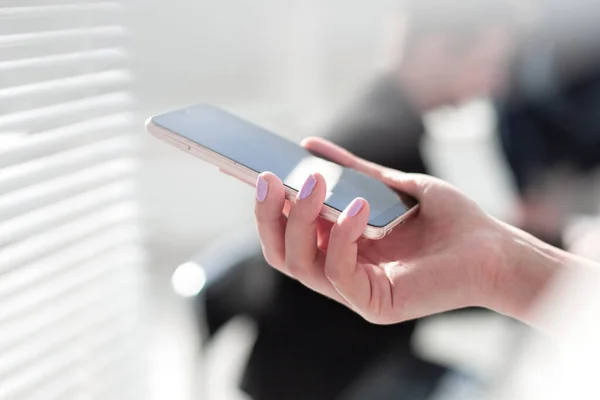 Hand kvinna med hjälp av smartphone på träbord, Plats för text eller design. — Stockfoto