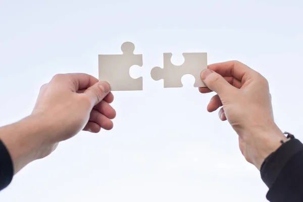 Dvě 2 ruce se snaží spojit pár puzzle kus — Stock fotografie