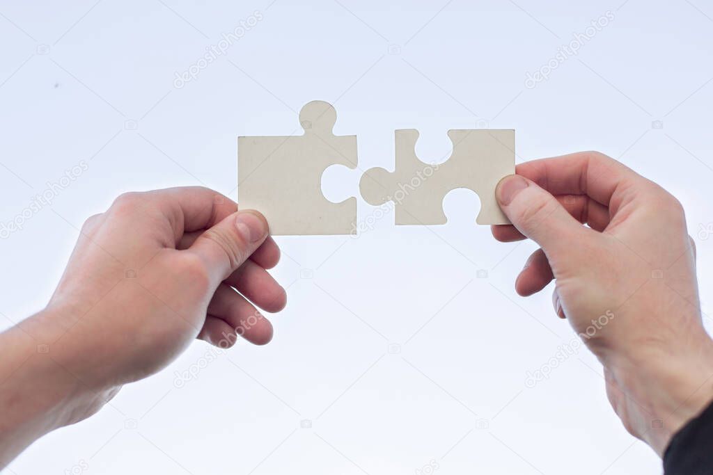 two 2 hands trying to connect couple puzzle piece