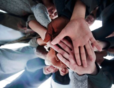 Alt manzara. Bir grup mutlu genç insan ellerinden bir kule yapıyorlar. .