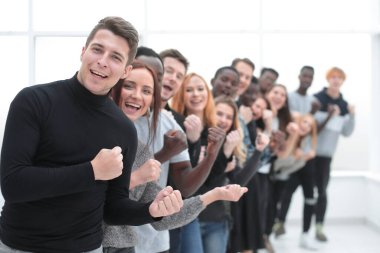 Genç adam bir grup gencin önünde duruyor.