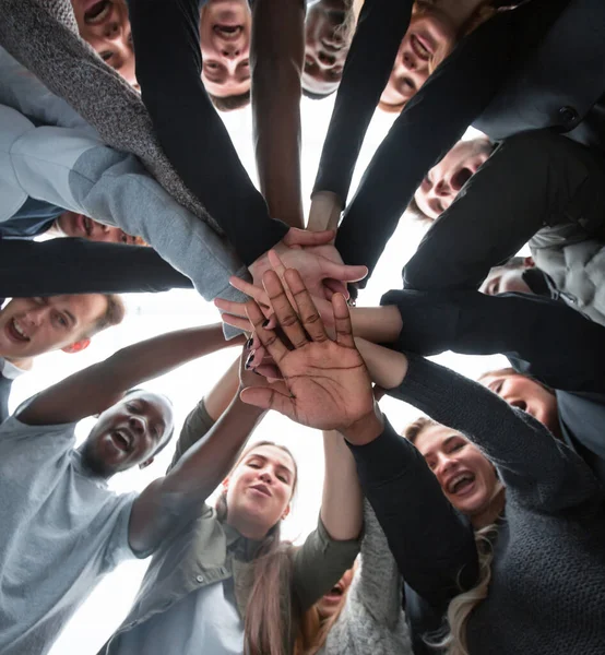 Vue du bas. groupe de jeunes heureux faisant une pile de mains — Photo