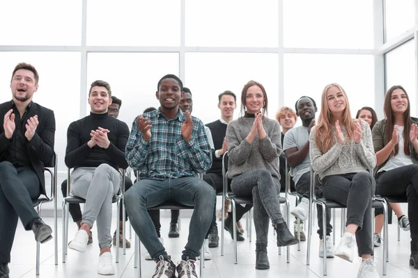Mosolygó fiatalok tapsolnak egy üzleti szemináriumon. — Stock Fotó