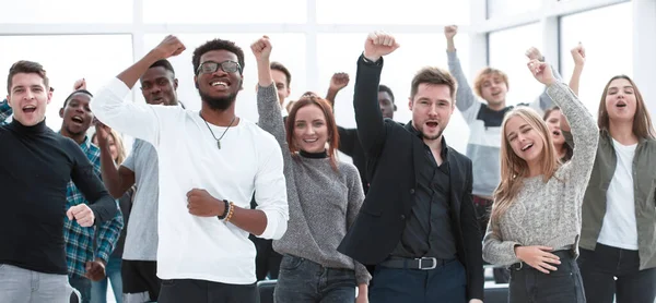 Grupp glada unga människor står med händerna upp — Stockfoto