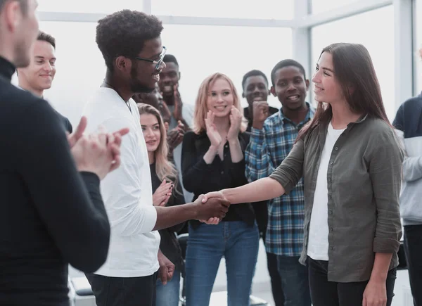 Grupo de jóvenes felices felicitando a su colega —  Fotos de Stock