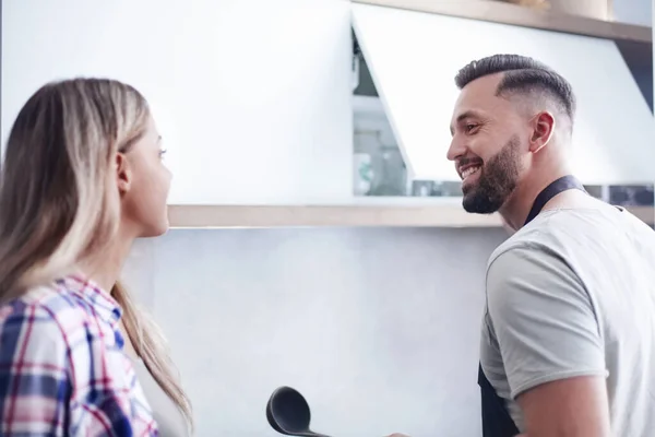 Casal feliz discutindo o menu de pé na cozinha — Fotografia de Stock