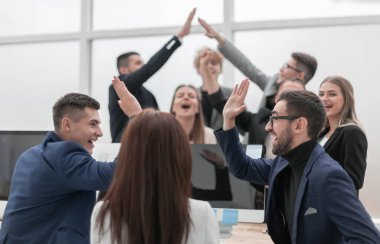 Bir grup genç iş adamı birbirlerine beşlik çakıyor.