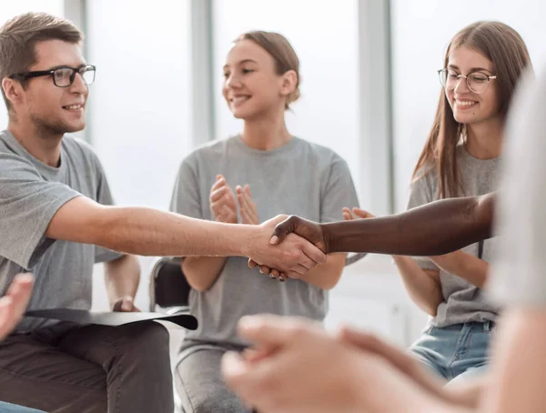 Apretón de manos de los jóvenes en un círculo de personas de ideas afines . — Foto de Stock