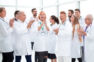 Bir grup farklı gülümseyen doktor alkışlıyor..