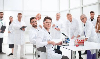 Genç bilim adamı ve meslektaşları laboratuvarda çalışıyor..