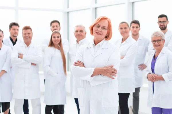 Ανώτερες γυναίκες γιατρός στέκεται μπροστά από τους συναδέλφους της. — Φωτογραφία Αρχείου