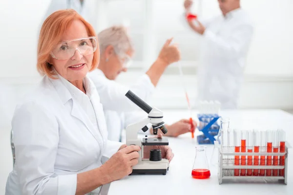 Cientista fêmea realiza um exame de sangue no laboratório. — Fotografia de Stock
