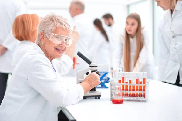 Cientista sentada em uma mesa no laboratório. — Fotografia de Stock