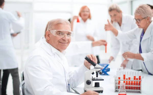 Cientista sorridente no local de trabalho no laboratório. — Fotografia de Stock