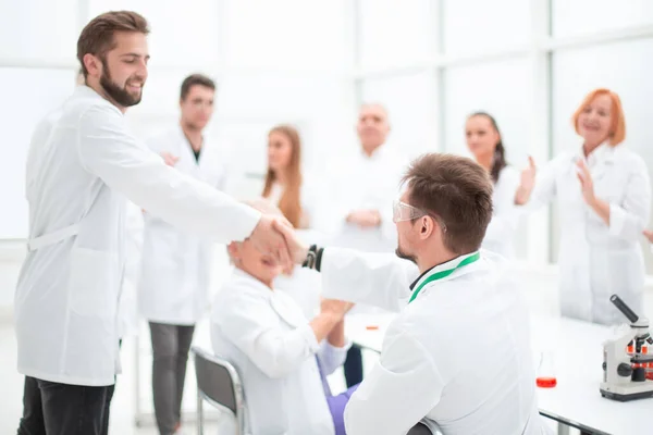 Gruppo di scienziati che si congratulano con il loro collega sul posto di lavoro — Foto Stock