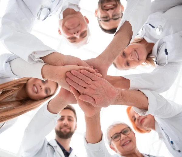 Close up. group of different doctors putting their hands together — Stock Photo, Image