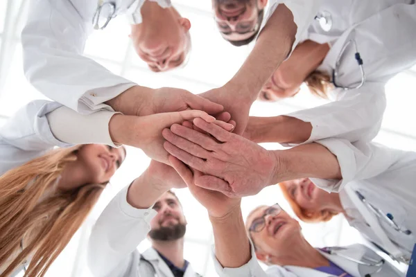 Zamknij się. grupa różnych lekarzy składających swoje dłonie — Zdjęcie stockowe