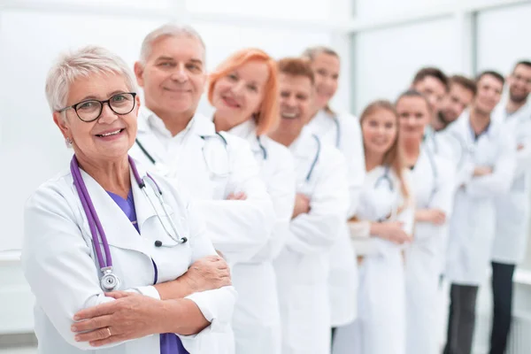 Senior medico femminile in piedi di fronte ai suoi colleghi. — Foto Stock