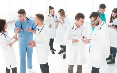 bir grup tıbbi personel iş belgelerini tartışıyor.