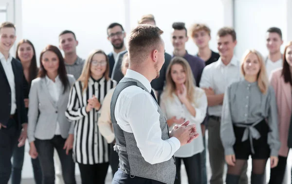 Joven líder mirando a un feliz equipo de negocios . — Foto de Stock