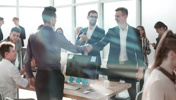 Durch das Glas. junge Geschäftsleute, selbstbewusst Hände schüttelnd. — Stockfoto