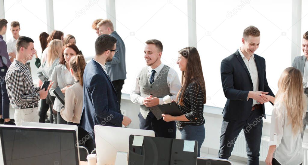group of young employees discussing work issues