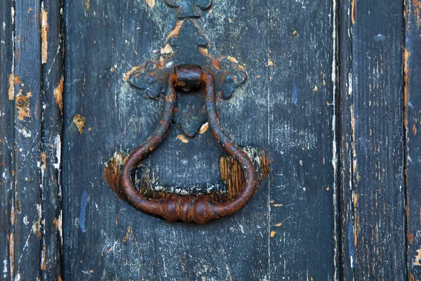 Латунный стук по старой деревянной двери в Лиссабоне — стоковое фото