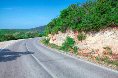 Boş yol ve ağaçların altında bulutlu gökyüzü manzara