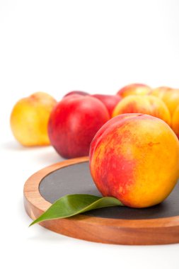 Beyaz izole ahşap kesme tahtası üzerinde taze yıkanmış şeftali 