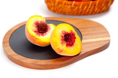 Beyaz izole ahşap kesme tahtası üzerinde taze yıkanmış şeftali 