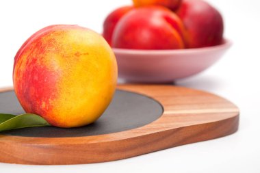 Beyaz izole ahşap kesme tahtası üzerinde taze yıkanmış şeftali 