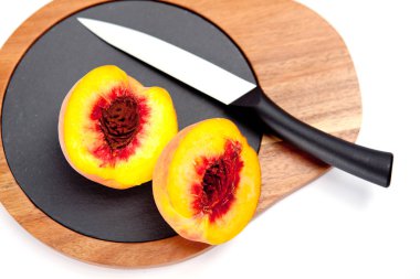 Bıçak ile ahşap kesme tahtası üzerinde taze yıkanmış şeftali